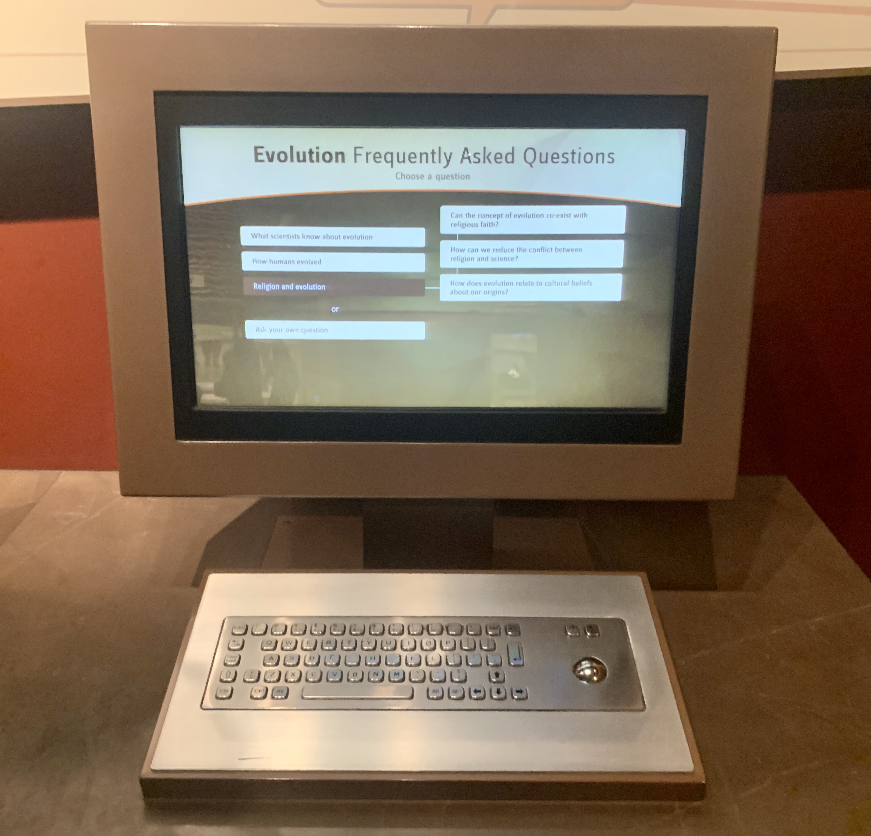 zoomed in picture of the Evolution FAQ computers and the display shows the religion and evolution questions.