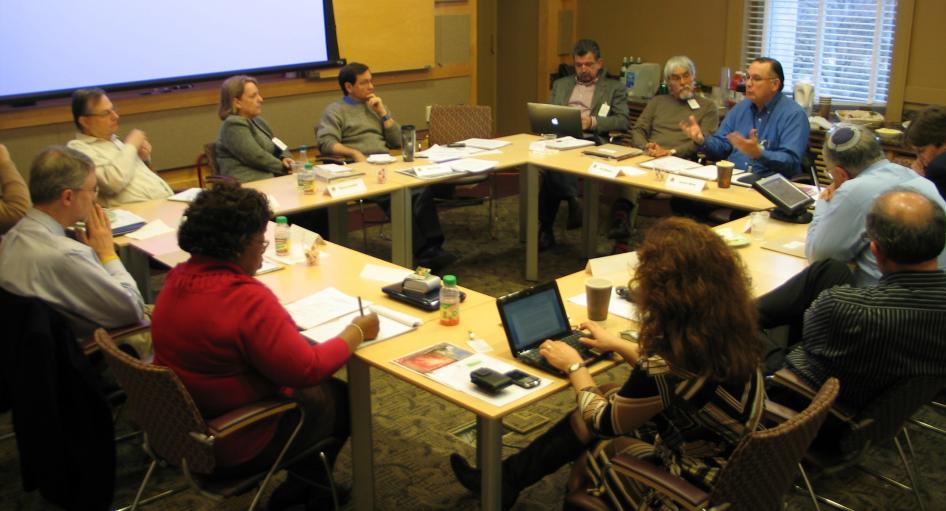 Photo shows a group of individuals in a conference room during one of the Broader Social Impacts committee meetings.